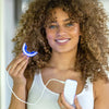 Vrouw met Diamond Smile Power+ Phone Bleaching mondstuk LED spalk in de hand